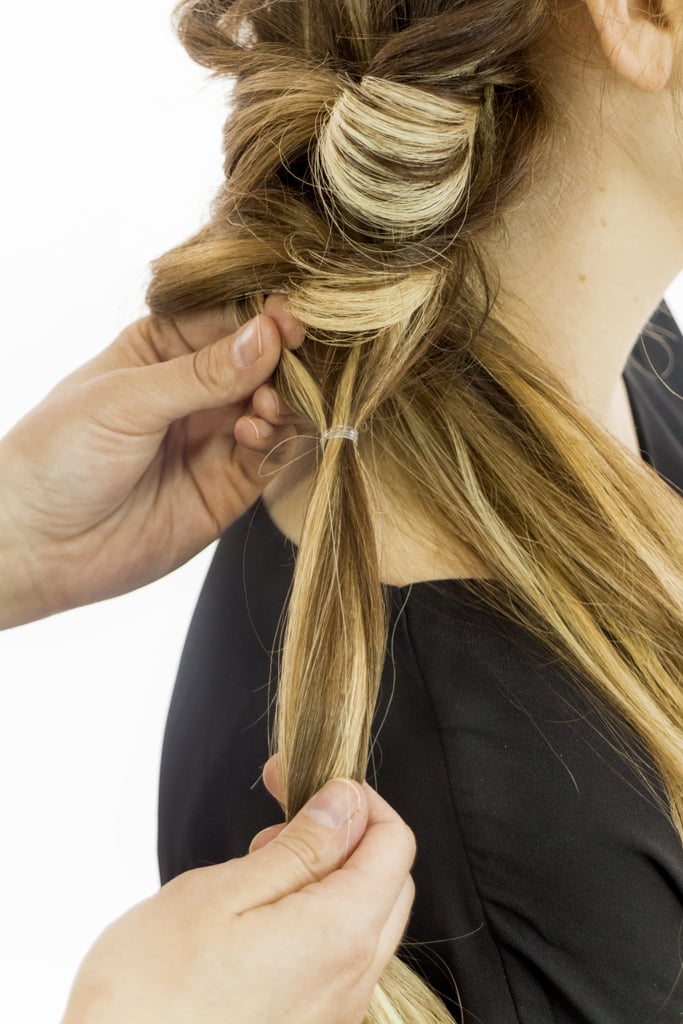 Working down the same ponytail, repeat the process you just completed: secure strands with an elastic, turn that new ponytail inside out, and pancake the base. Repeat this on that one section until you have about two inches of hair left. Then backcomb these strands, adding texture and volume to the braid.