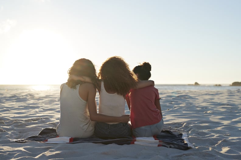 Young women hanging out at the beach, at sunset