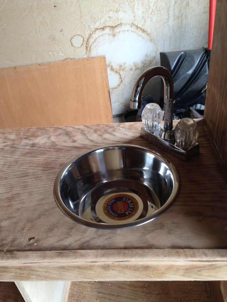 They used a metal dog bowl for a sink and glued on a faucet.