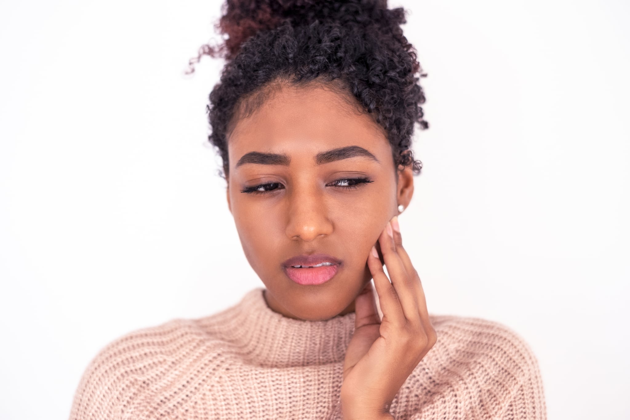 Portrait of young black woman suffering dental pain isolated on white background