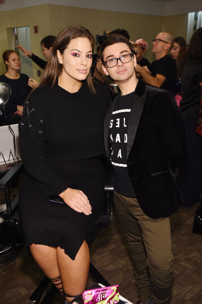 Backstage wearing a black sweater and skirt with designer Christian Siriano.