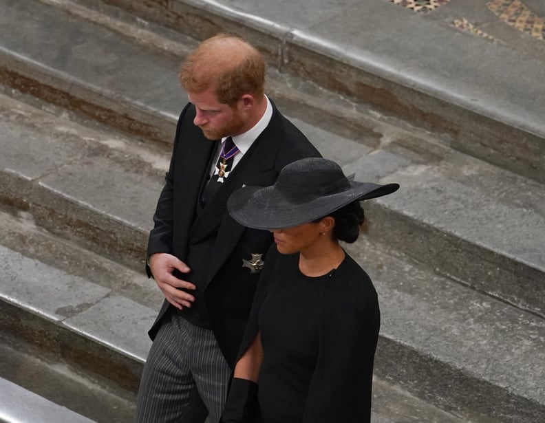 LONDON, ENGLAND - SEPTEMBER 19:  Prince Harry, Duke of Sussex and Meghan, Duchess of Sussex follow the bearer party with the coffin as they take part in the state funeral and burial of Queen Elizabeth II at Westminster Abbey on September 19, 2022 in Londo
