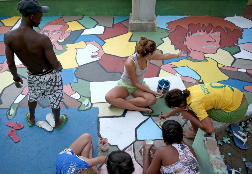 A group gathered to paint a World Cup mural on the street in Rio de Janeiro.
