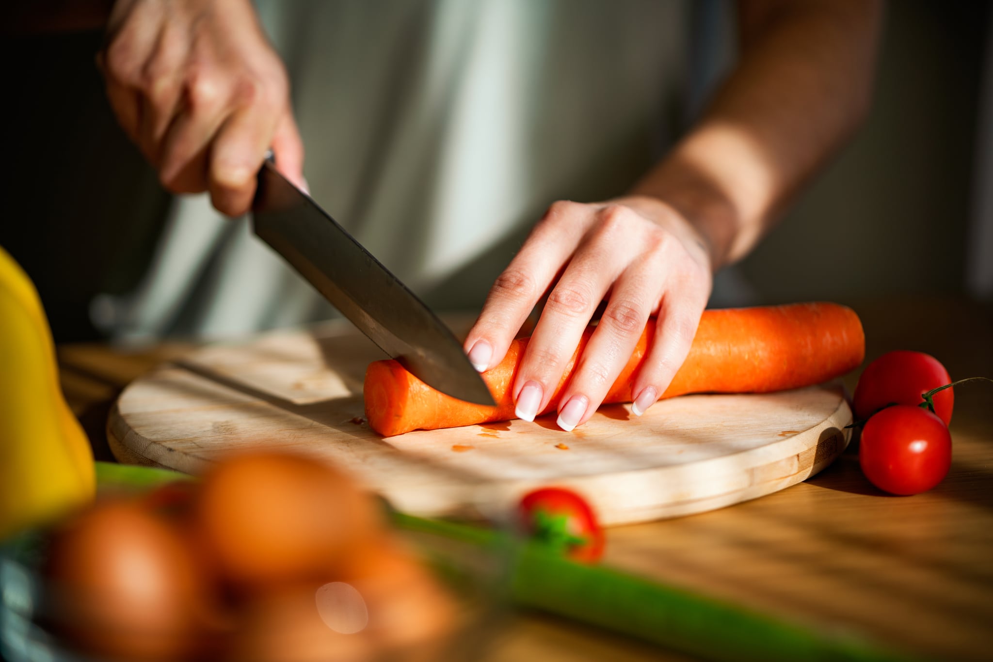 Close-up of a woman chopping vegetables in the kitchen