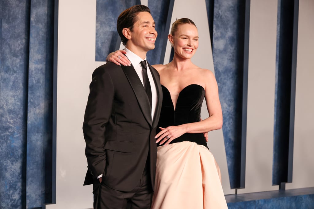 Over a year into their relationship, Kate Bosworth and Justin Long officially made their red carpet debut at the Vanity Fair Oscars party on March 12. Wearing a chic plunging gown by Monique Lhuillier, the "Blue Crush" actor smiled for the cameras with her hand on Long's chest, offering a view of her massive diamond ring. Though reps for the actors have not confirmed their engagement, it sure looks like the couple is headed toward the aisle. 
On March 15, Bosworth seemed to reference the news on Instagram alongside film photos from the Oscars afterparty. Among a list of credits that included Long and her glam team for bringing her beautiful look to life, she thanked her nail artist Ashlie Johnson for her "most important manicure to date." Johnson also referenced Bosworth's "new bling" in a post of her own, further hinting at an engagement. 
Bosworth's ring appears to be a classic, round-cut diamond set on a thin silver band. The sparkler is estimated to be about 10 carats and valued at $500,000, according to diamond expert Mike Fried, CEO of The Diamond Pro. "A diamond of this size is incredibly rare," he told POPSUGAR. Bosworth has yet to share a close-up of the round-cut diamond, known as a traditional shape that never goes out of style. 
The new accessory complemented Bosworth's regal gown, which featured a black velvet corset and a floor-length pale pink skirt from the designer's fall 2023 collection. Coincidentally, Lhuillier is known for her exquisite bridal wear, so perhaps the two are subtly offering a hint at a collaboration in the future. Styled by Samantha McMillen, Bosworth finished the minimalist look with Cicada jewels, including a ring on her right hand and diamond earrings. 
Long looked sleek in a black Berluti suit and tie, and was seen straightening out his rumored fiancée's gown while drawing attention to her gorgeous ensemble. The couple appeared blissful as they shared kisses and stared lovingly at one another both on the carpet and inside the party. Get a closer look at the pair's coordinating looks — and the giant diamond ring — in the photos ahead. 
Related:
See Every Outfit Change and Breathtaking Arrival at the Vanity Fair Oscars Party