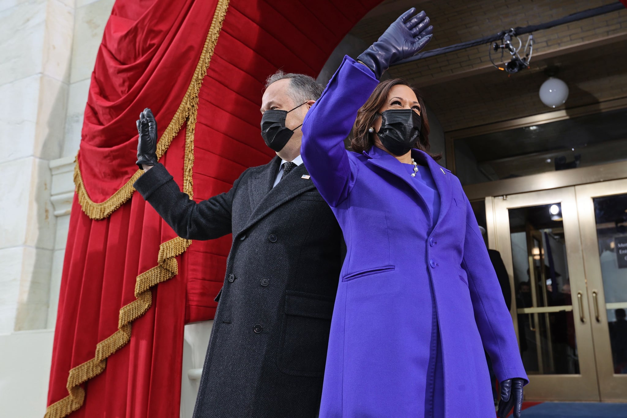 US Vice President-elect Kamala Harris (R) and US Second Gentleman Doug Emhoff wave as they arrive for the inauguration of Joe Biden as the 46th US President, on the West Front of the US Capitol in Washington, DC on January 20, 2021. (Photo by JONATHAN ERNST / POOL / AFP) (Photo by JONATHAN ERNST/POOL/AFP via Getty Images)