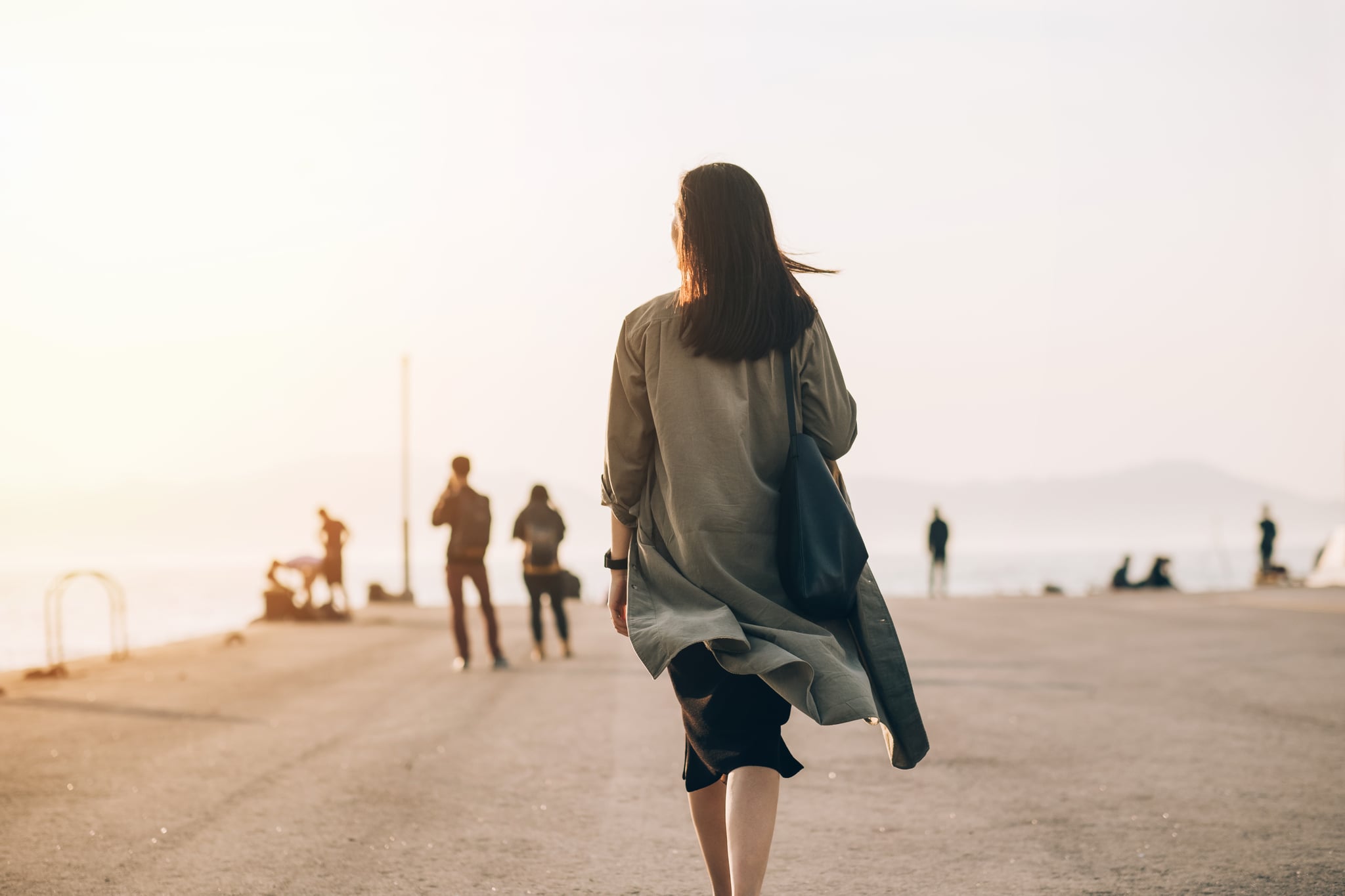 女人享受日落的惊人的视图的港口