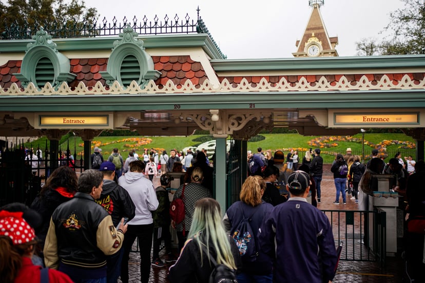 ANAHEIM, CA - MARCH 13: People wait in line to enter Disneyland on March 13, 2020 in Anaheim, California. Disney's two Southern California Theme Parks, California Adventure and Disneyland are shutting down temporarily until the end of March as a result of