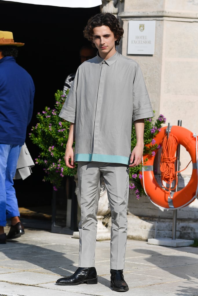 Smizing for the cameras in a grey button-down shirt with matching trousers by Haider Ackermann.