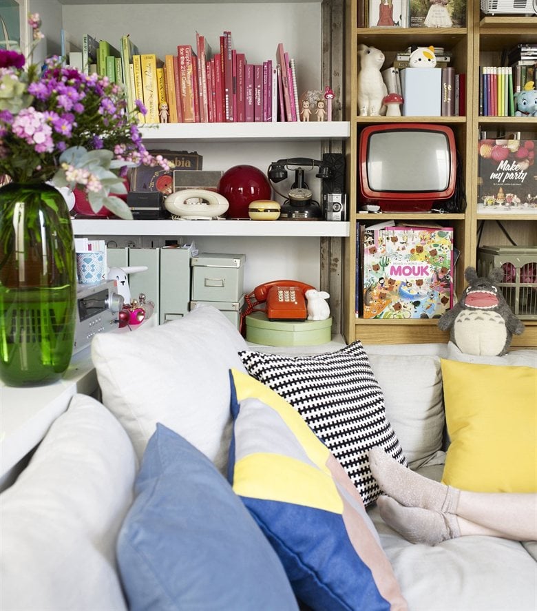 Color-coding adds playful interest to the bookshelf, while attractive boxes are used to stylishly organize the rest of Éléonore's belongings.