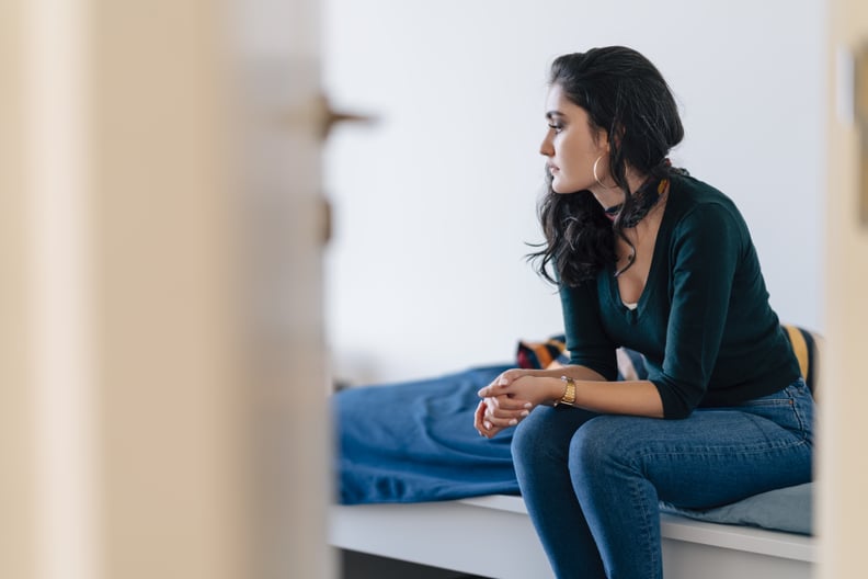 A lonely young woman is sitting alone in a room.