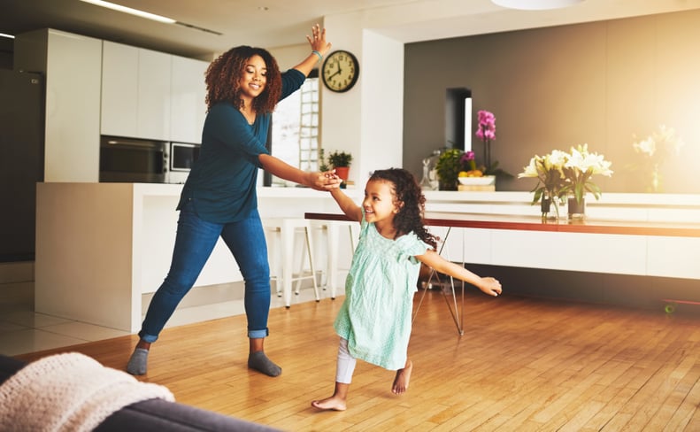 Shot of a little girl and her mother dancing at home