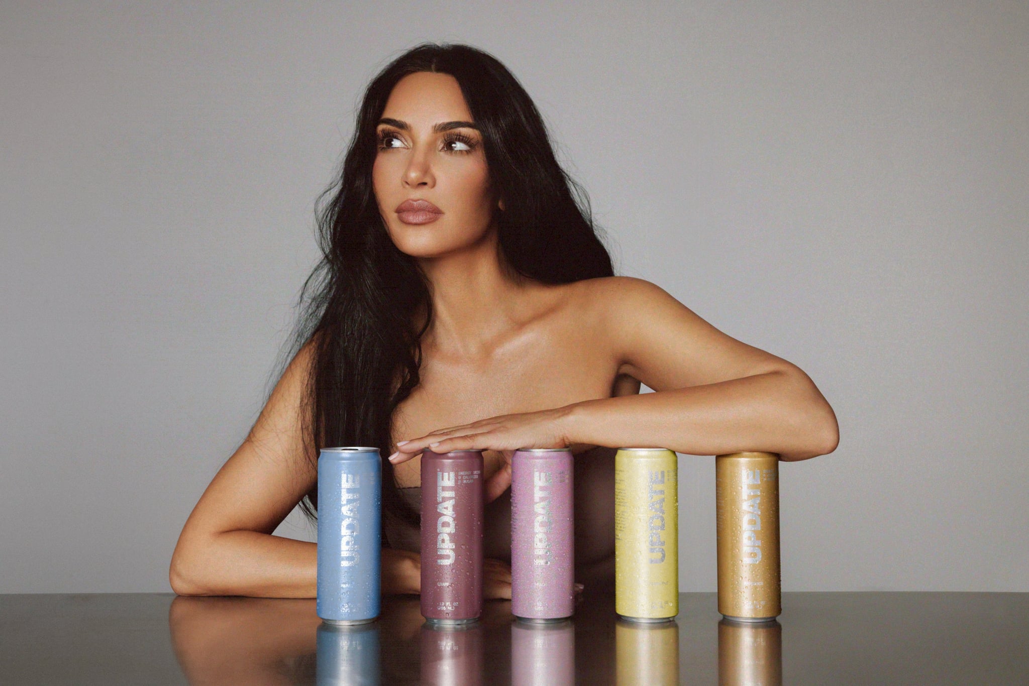 Kim Kardashian holding colorful canned drinks.