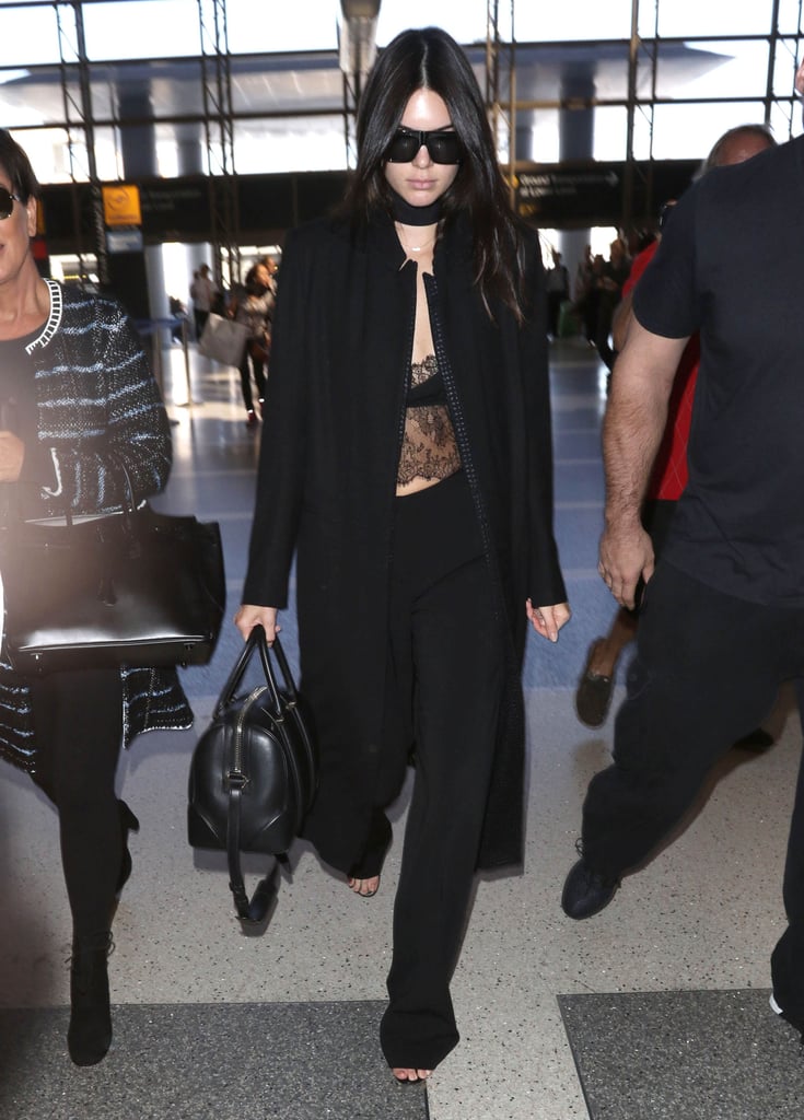Kendall headed to Paris Fashion Week wearing a sexy lace top, choker necklace, and black trousers.