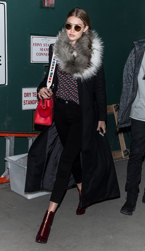 Gigi stepped out in a look that felt slightly '70s inspired after the DVF show. She wore a top printed with graphic hearts — for Valentine's Day — black skinny jeans, red zipper-front boots, a luxe coat, and a furry scarf. Gigi accessorized with round KREWE du optic printed sunglasses and a Fendi bag.