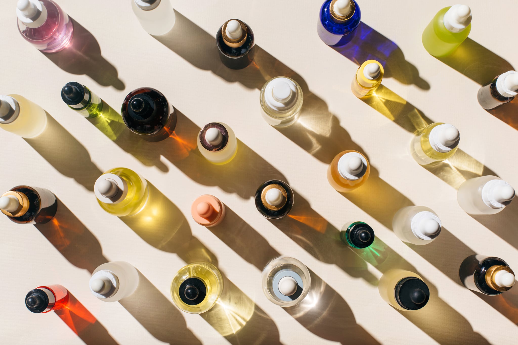 Glass bottles for cosmetic products with pipette, natural skincare and essential oil on beige background. Beauty products. Multitasking beauty, skinmalism, Skin care concept.