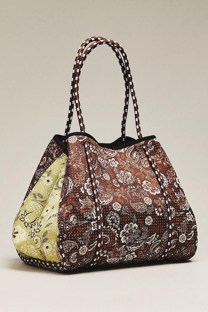Pop Ups Brand Everyday Tote ($135) 
Who said gym bags needed to be monochrome? This bold paisley print adds a little fun to your workout routine. Thanks to the flexible shell and forgiving fabric, there is no activity this bag can't keep up with. 
Pros: The fabric is water resistant and breathable, which is ideal for storing sweaty post-gym items
Cons: While there are two interior compartments, they might be too small for larger items like a laptop or extra shoes
Material: Neoprene
Dimensions: 21" W x 11" H x 9" L
Colorways: Four
Who It's Best For: If you tend to be hard on your things or want to wash your gym bags often, then this was designed with you in mind 
What Reviewers Say: "Not a bag person. Then I got this bag. The neoprene is lightweight but structured — doesn't flop, doesn't dig into your shoulder. It holds more than it looks like it should. When you clean it in the washing machine it comes out looking new."