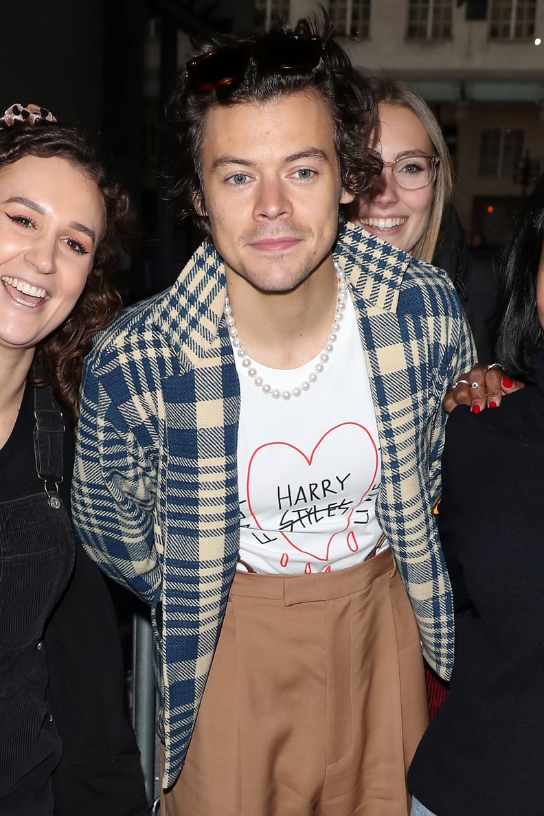 哈利风格穿着他的细线的t恤与球迷在伦敦