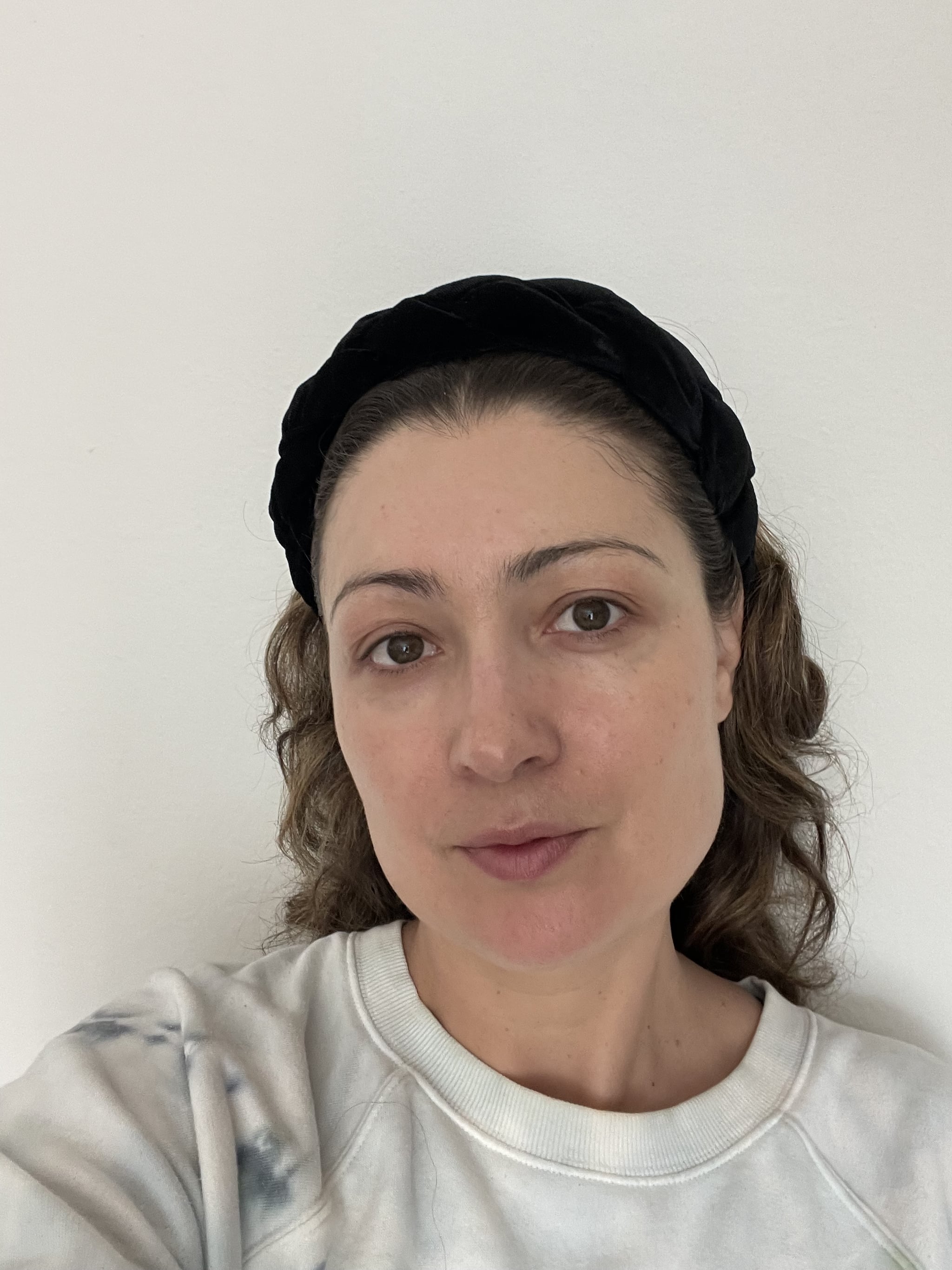 Woman's face before applying It Cosmetics CC+ Color Correcting Full Coverage Cream