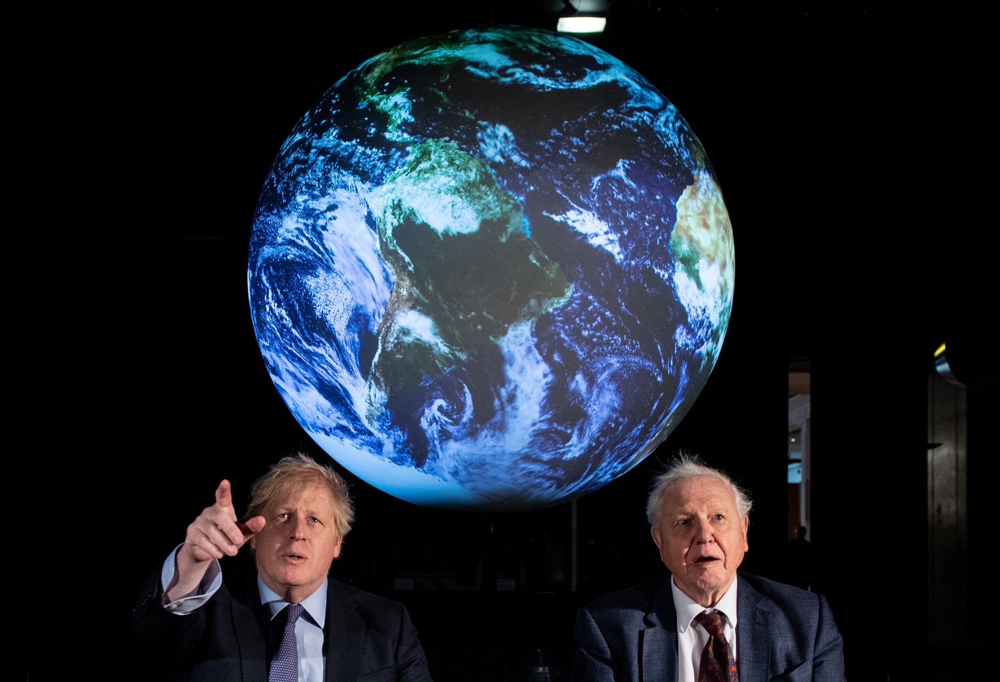 LONDON, UNITED KINGDOM – FEBRUARY 4:  British Prime Minister Boris Johnson (L) and British broadcaster and naturalist Sir David Attenborough speak with school children during the launch of the UK-hosted COP26 UN Climate Summit, which will take place this autumn in Glasgow, at the Science Museum on February 4, 2020 in London, England. Johnson will reiterate the government's commitment to net zero by 2050 target and call for international action to achieve global net zero emissions. The PM is also expected to announce plans to bring forward the current target date for ending new petrol and diesel vehicle sales in the UK from 2040 to 2035, including hybrid vehicles for the first time. (Photo by Chris J Ratcliffe-WPA Pool/Getty Images)