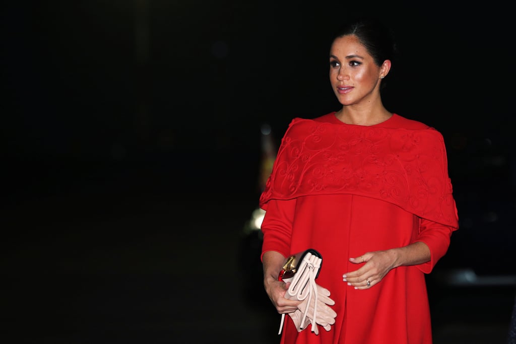 Prince Harry and Meghan Markle have landed in Morocco for a short tour of the North African country. The duke and duchess are visiting Morocco on behalf of the British government, and their tour will focus on learning more about youth empowerment and girls' education in the country, causes that are close to both of their hearts.
The trip is set to include a whole host of events, including cooking demonstrations, a henna ceremony, and an evening reception, so we can expect many outfit changes from Meghan in the next few days. She definitely kicked things off in style after the short flight from London, when she stepped off the plane in Casablanca wearing a gorgeous red Valentino dress with off-the-shoulder cape detail, her second chic travel look in less than a week. Keep reading for all the photos, and stay tuned for more from this miniature royal tour.