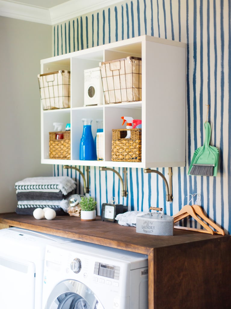 With hooks to hang cleaning supplies and multi surfaces for items to sit on, there's a place for everything. And when everything has a place, it's easy to keep it tidy and organized. To give the whole space a high-end, high-design look, Monica elevated everyday essentials with more stylish versions, like a mint green dustpan and
bamboo ironing board ($57).