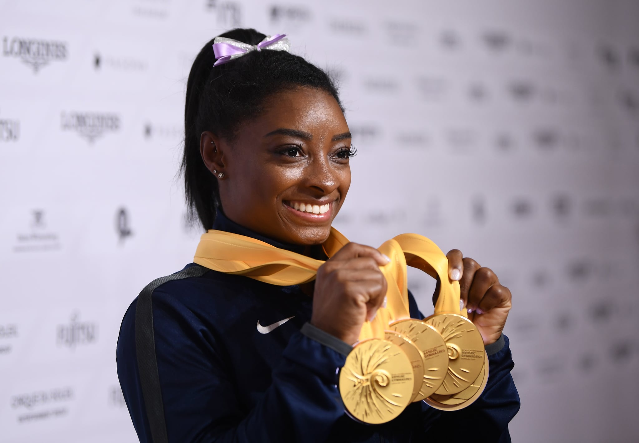 STUTTGART, GERMANY - OCTOBER 13: Simone Biles of USA poses with her Medal haul after the Apparatus Finals on Day 10 of the FIG Artistic Gymnastics World Championships at Hanns Martin Schleyer Hall  on October 13, 2019 in Stuttgart, Germany. (Photo by Laurence Griffiths/Getty Images)