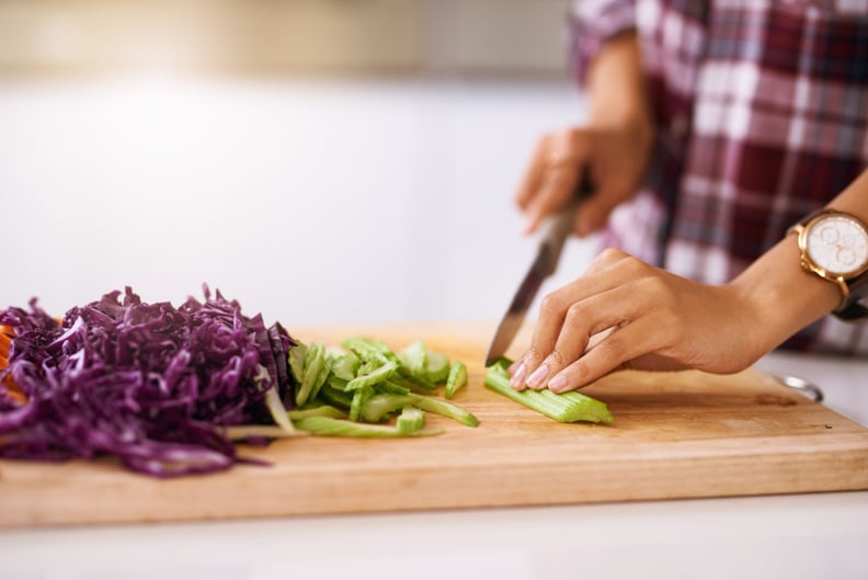 Cropped shot of an unrecognizable woman cutting vegetables in the kitchen at home