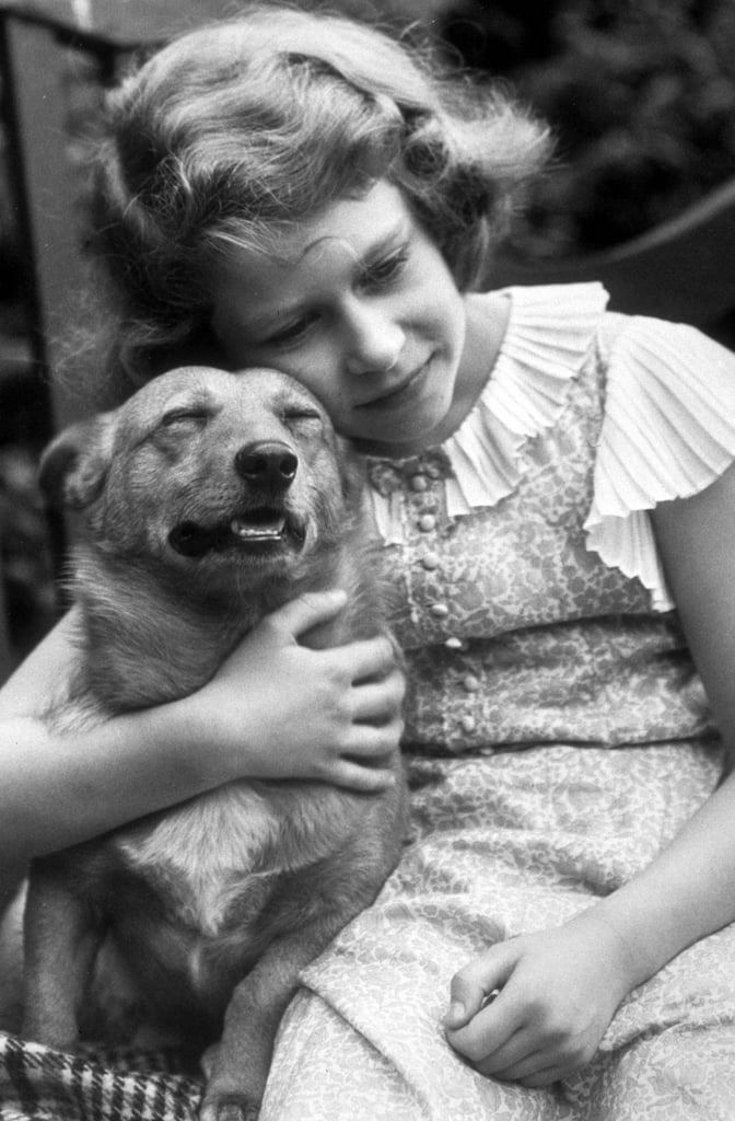 A young Princess Elizabeth snuggled with one of her first Corgis back in 1936.