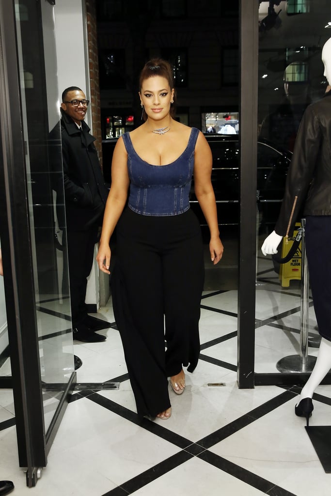 Attending the launch of her denim capsule collection with Marina Rinaldi wearing a denim tank top, black trousers, and clear heels.