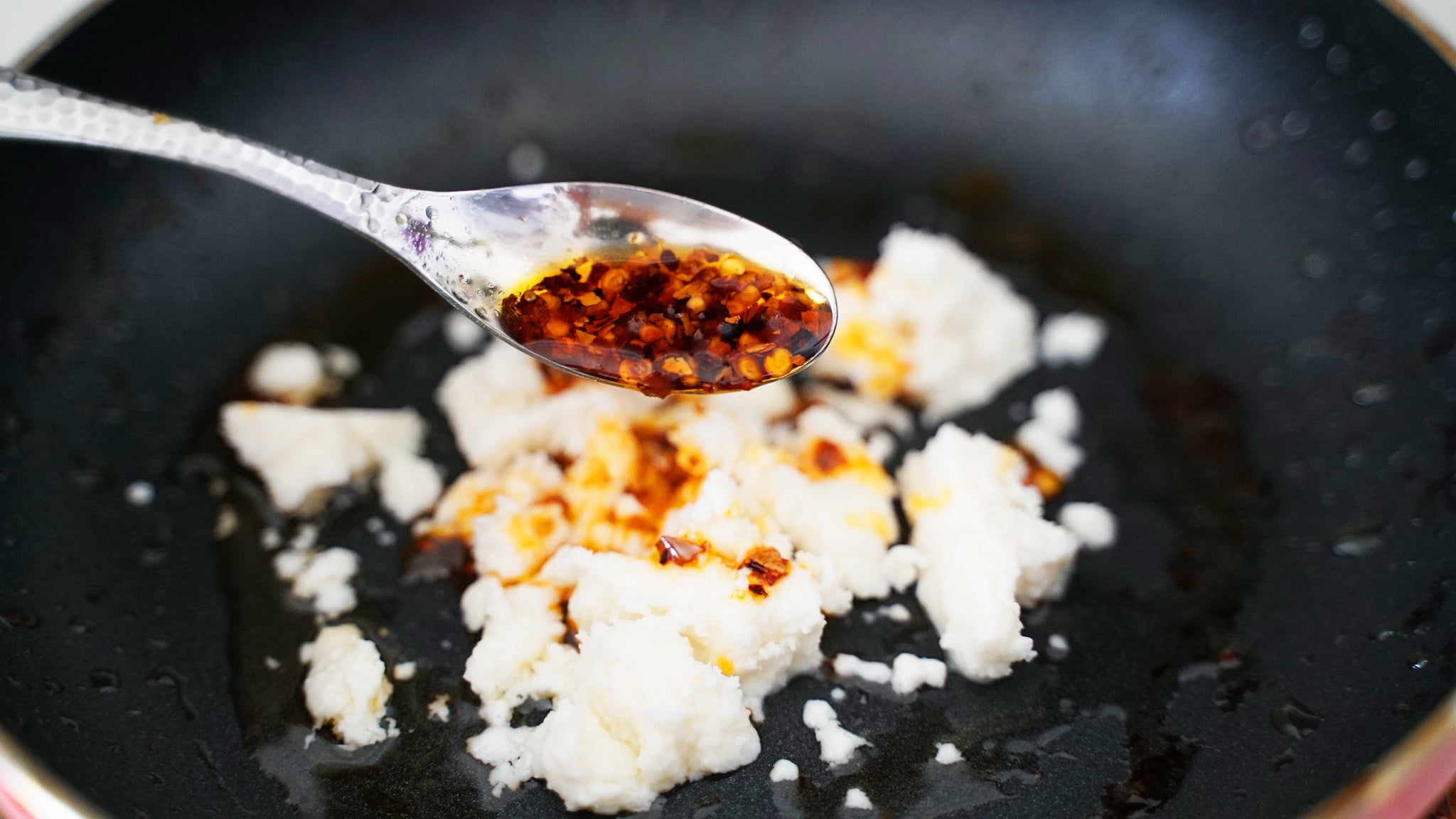 how to make feta fried eggs: feta in pan with chili oil