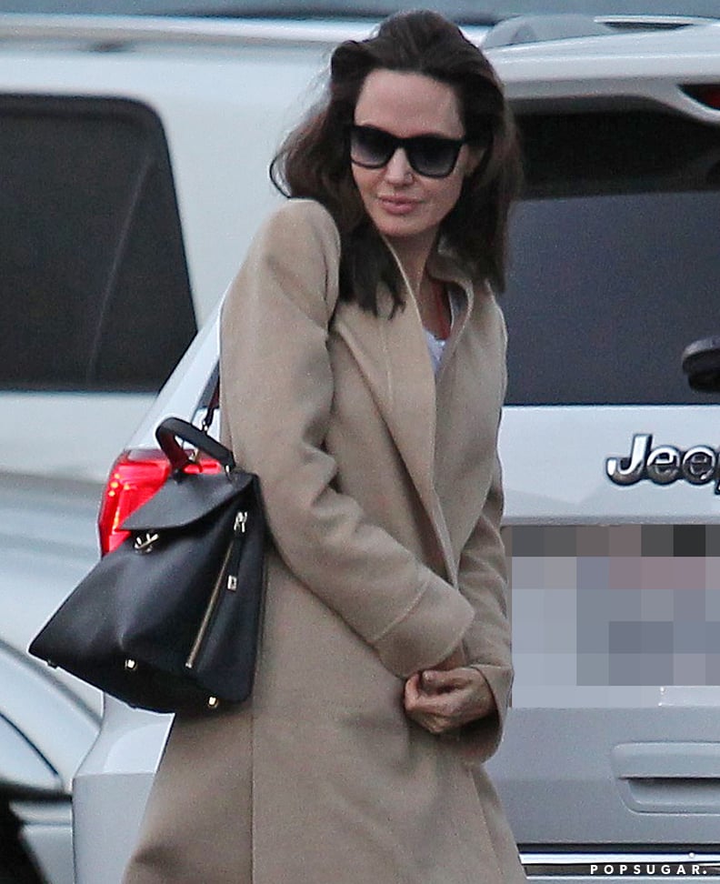 Angelina Jolie Wears Oversize Coat & Satin Scarf for Shopping Trip