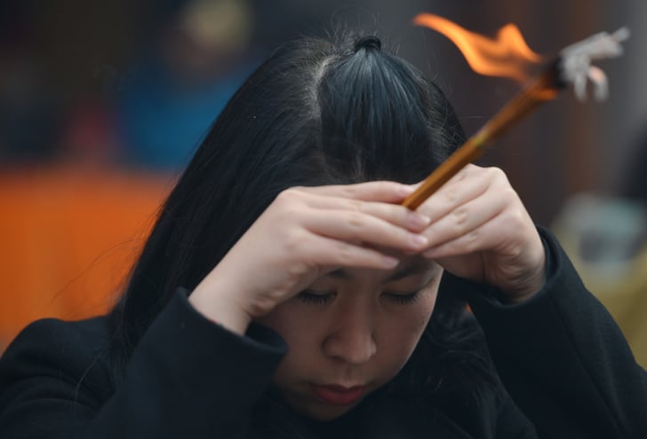 A woman carried incense as part of the prayer traditions. | Chinese New