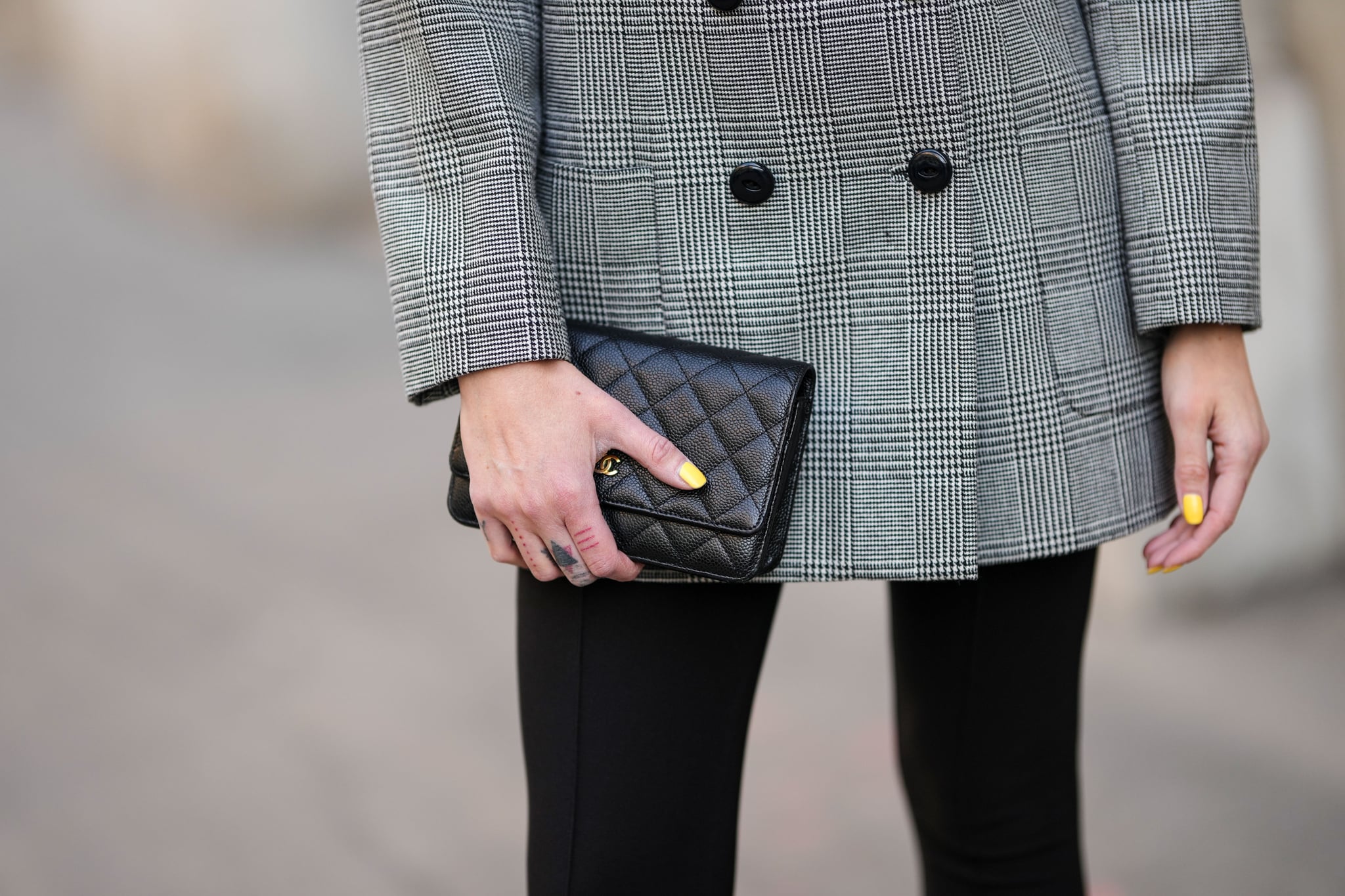 PARIS, FRANCE - MARCH 19: Emy Venturini wears a black and white small houndtooth print pattern blazer jacket from YSL / Saint Laurent Paris, black legging pants, a black shiny grained leather clutch from Chanel, during a street style fashion photo session, on March 19, 2022 in Paris, France. (Photo by Edward Berthelot/Getty Images)