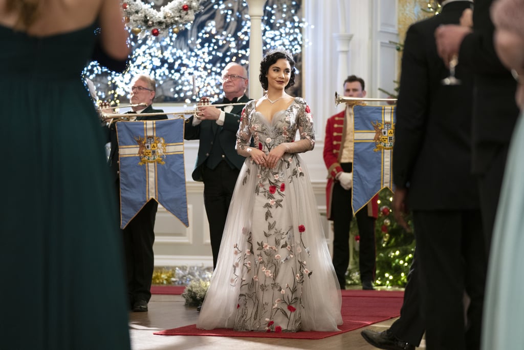 Wearing a stunning tulle gown covered with delicate floral embroidery.