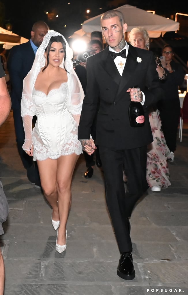 Kardashian's look was complete with white lace bridal pumps and sheer, mesh-dotted opera-length gloves. For the afterparty, she also added a shortened veil, and the couple proudly sported their Lorraine Schwartz diamond wedding bands.