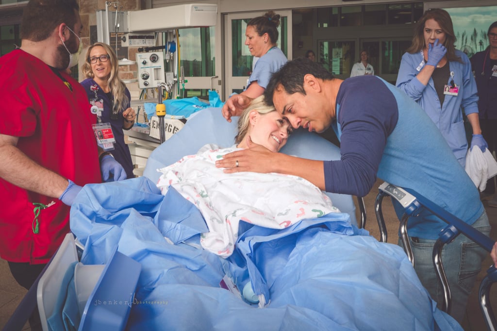 Mom and dad in front of the hospital with their baby girl.
