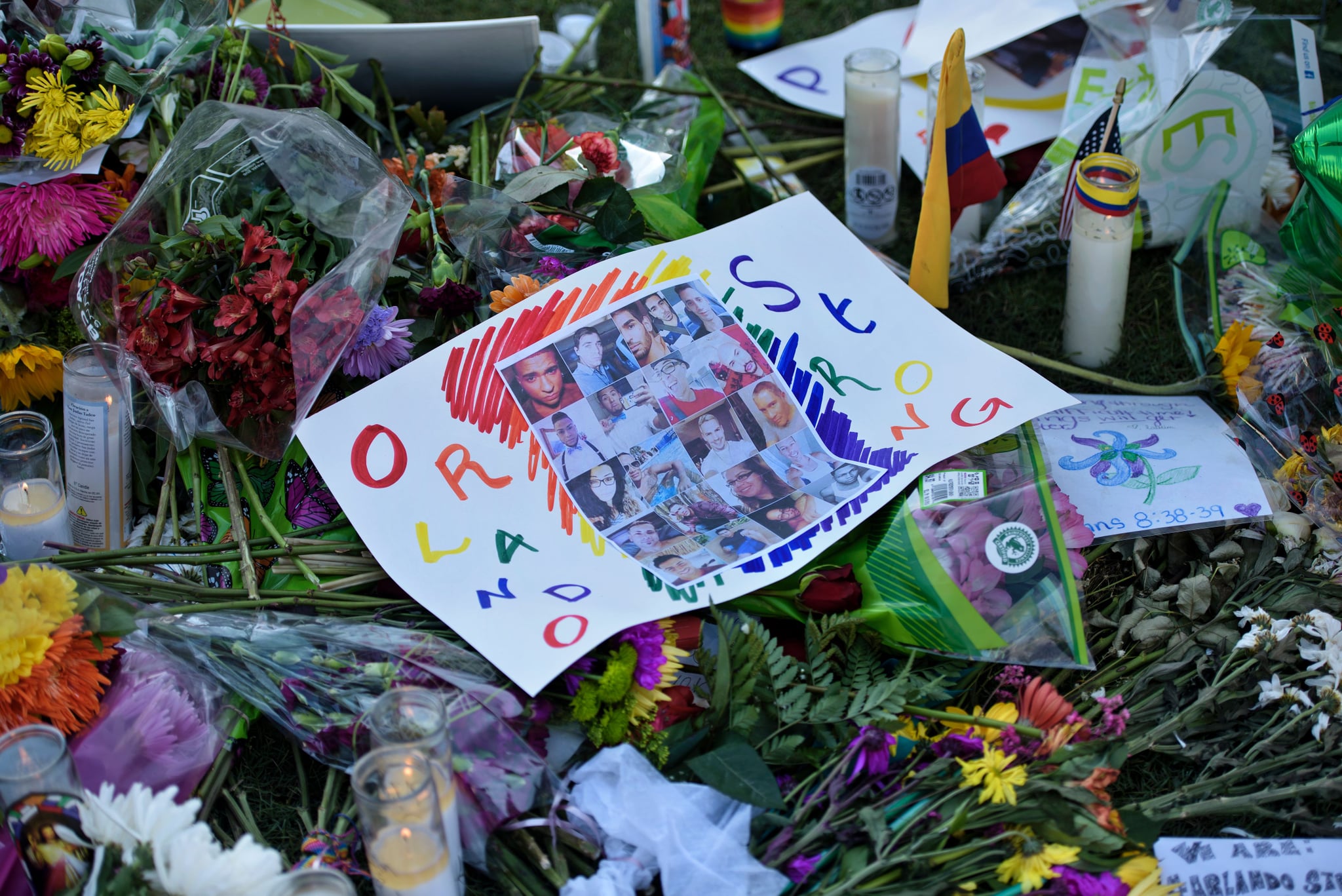 Photos and flowers are seen at a memorial at the Dr. Phillips Centre for the Performing Arts to honour the Pulse nightclub mass shooting victims June 14, 2016 in Orlando, Florida.The gunman who launched the worst terror attack on US soil since 9/11 at a gay nightclub in Orlando was radicalized by Islamist propaganda, officials said, amid reports he was a club regular. Lone gunman Omar Mateen killed 49 and wounded another 53 before he was killed when police stormed the Pulse, one of Orlando's most prominent gay venues, early Sunday. / AFP / Brendan Smialowski        (Photo credit should read BRENDAN SMIALOWSKI/AFP via Getty Images)