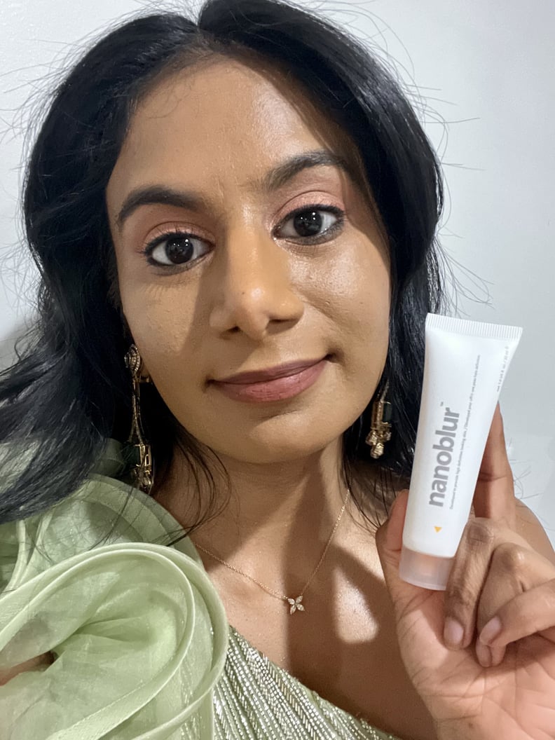 Woman holding the Indeed Labs Nanoblur Cream while showing the skin-blurring effect of the primer.