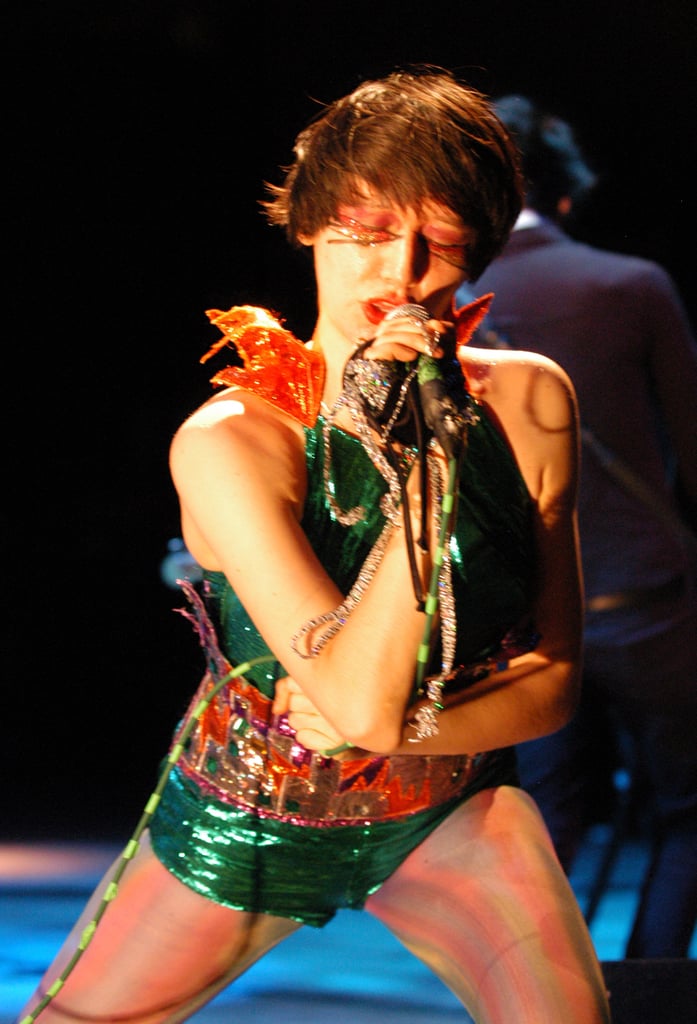 Wearing a green bodysuit with a colorful belt in 2006.