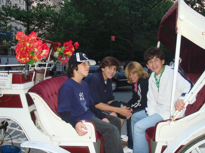 A photo of four 13-year-old quadruplet boys in a carriage.