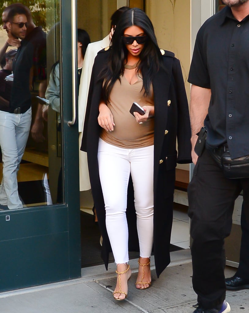 Kim chose a pair of white distressed skinny jeans and a slashed t-shirt, sticking to neutrals as per usual. She accented the buttons on her regal coat with gold chain strapped heels.