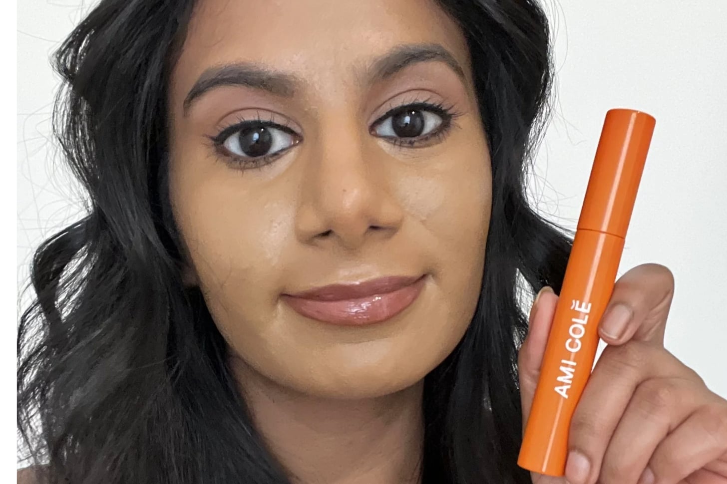 Woman holding the Ami Cole Lash Amplifying Mascara.