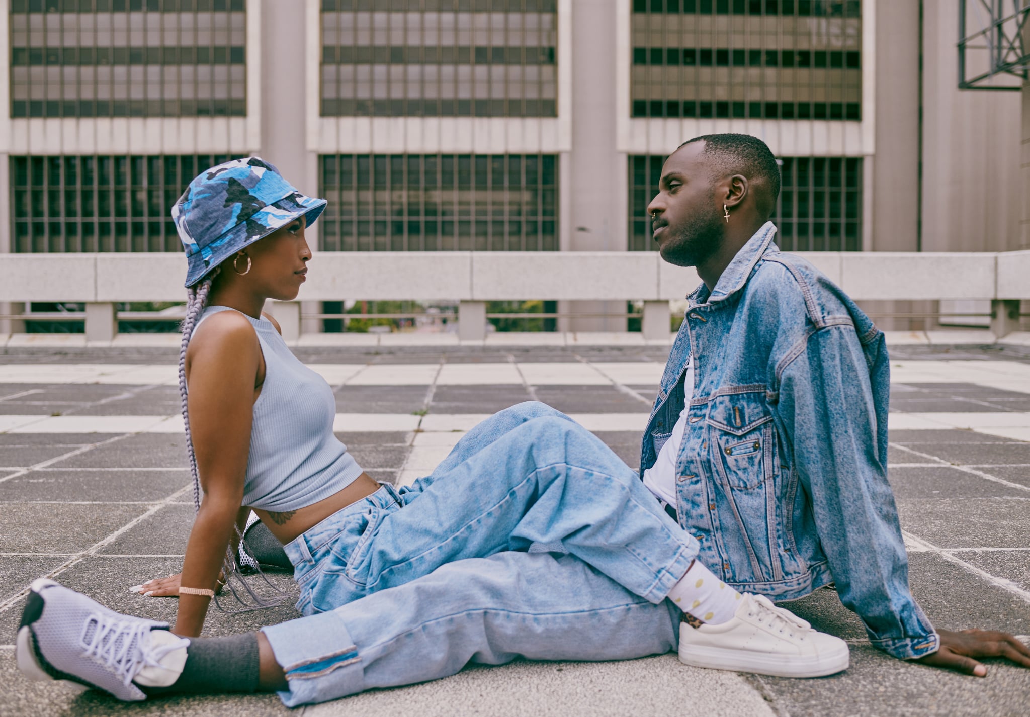 Shot of a trendy young couple sitting face to face against an urban background