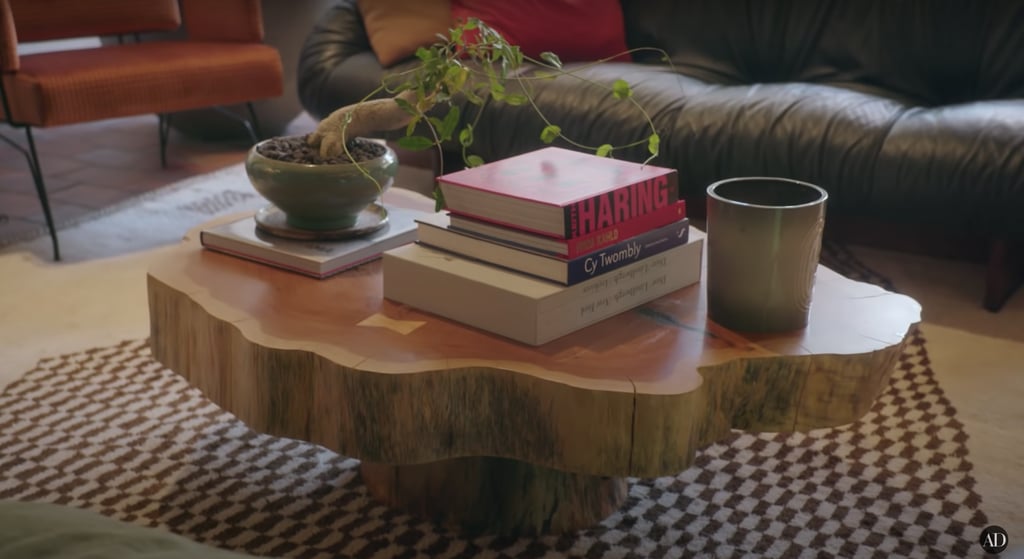 Troye's custom coffee table holds a bonsai tree and books featuring the works of Keith Haring, Freida Kahlo, and more.
