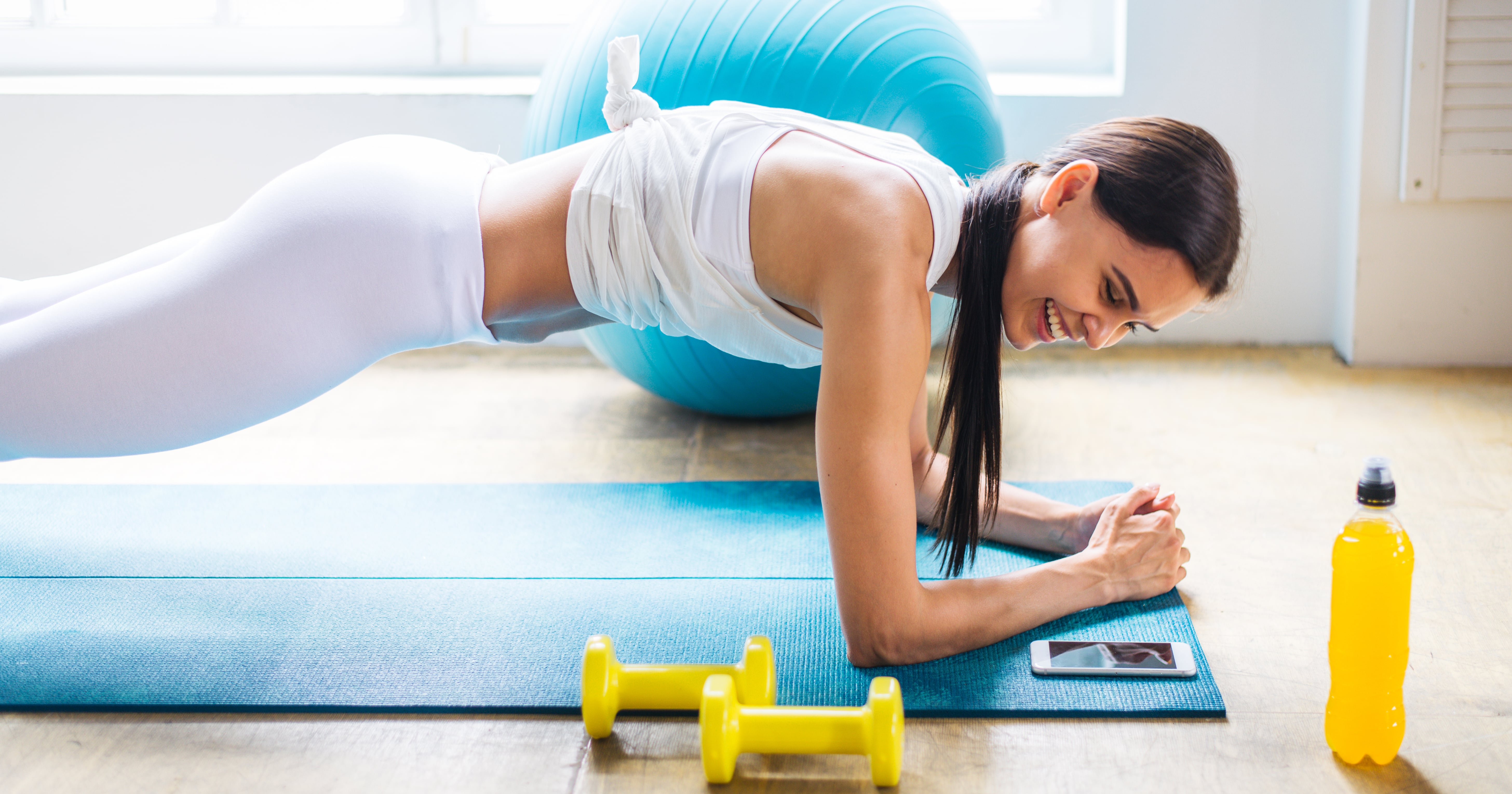Young women doing fitness exercises on the butt in the bright studio on yoga  mats Stock Photo