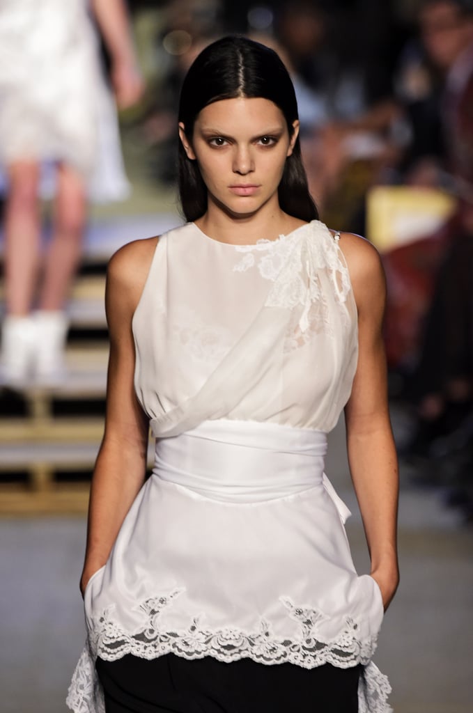 Kendall walked the runway at Givenchy wearing a white top with a waist wrap and lace detail.