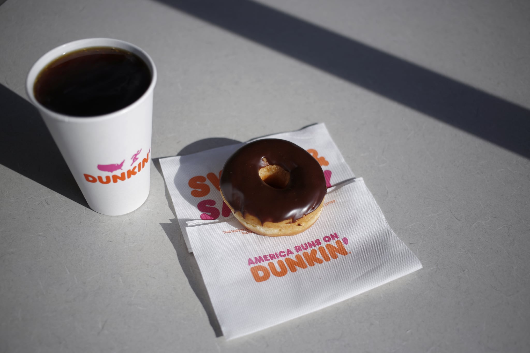A black coffee and chocolate frosted donut are arranged for a photograph inside a Dunkin' location in Mount Washington, Kentucky, U.S., on Thursday, Jan. 30, 2020. Dunkin' Brands Group Inc. is scheduled to release earnings figures on Feb. 6. Photographer: Luke Sharrett/Bloomberg via Getty Images