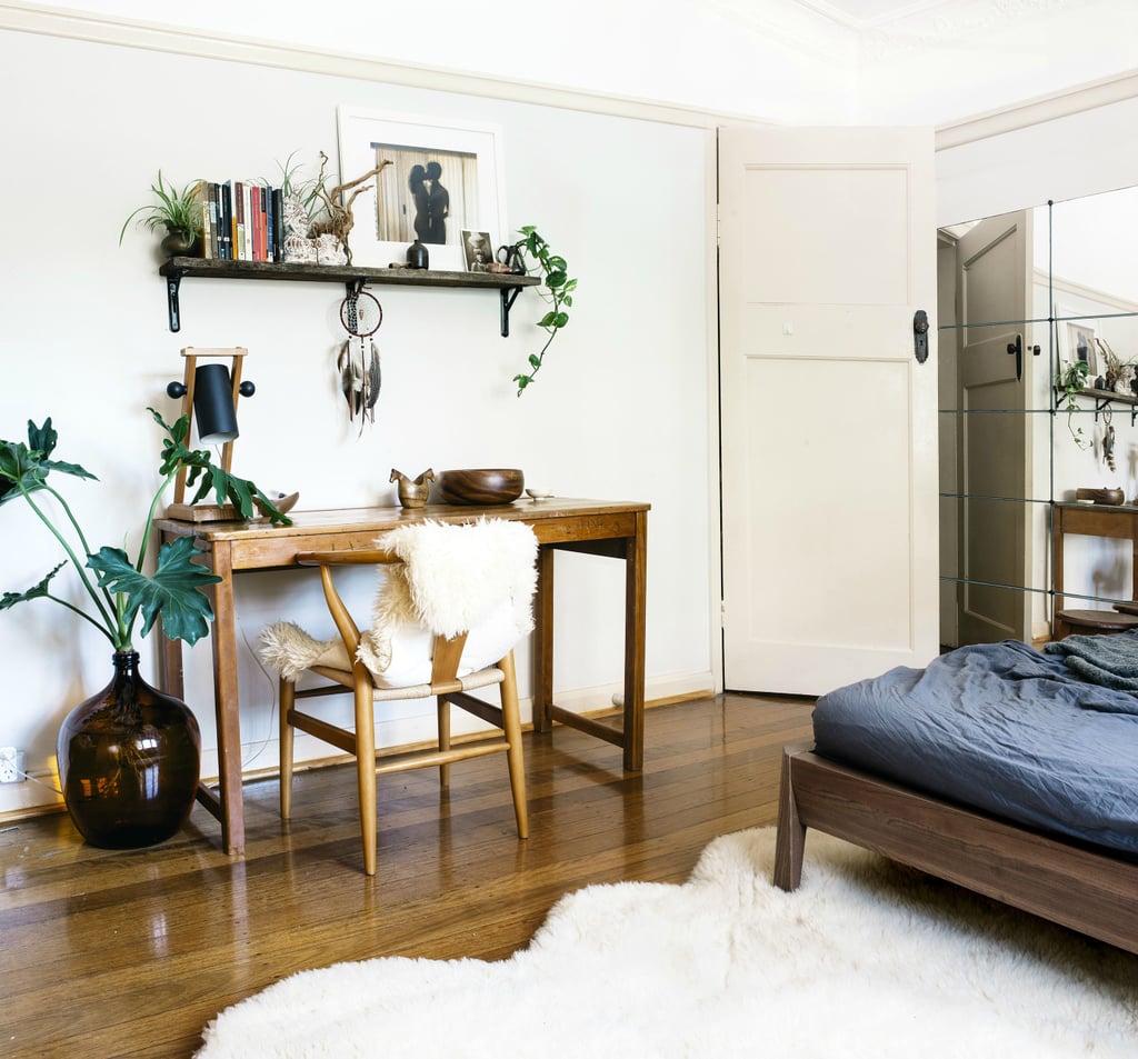 While the simple Scandinavian wood furniture in this bedroom-slash-office could come off as cold, the homeowner warmed it up with living greens and soft sheepskin throws.