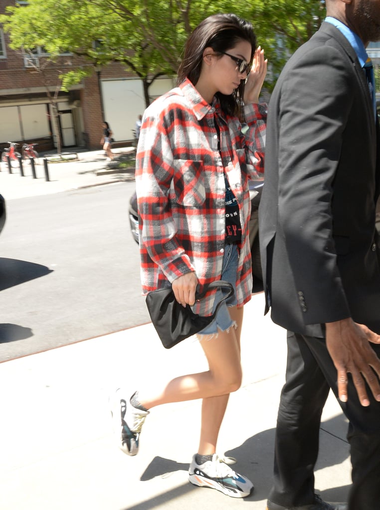 Kendall worked her Yeezy Boost 700 Wave Runner sneakers with denim cutoffs, her Prada bag, and a flannel in New York City.